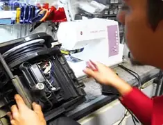Vacuum repair technician servicing internal components on a workbench in Fresno, CA