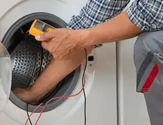 Washing machine repair technician testing a front-load washer with diagnostic tools in Fresno, CA